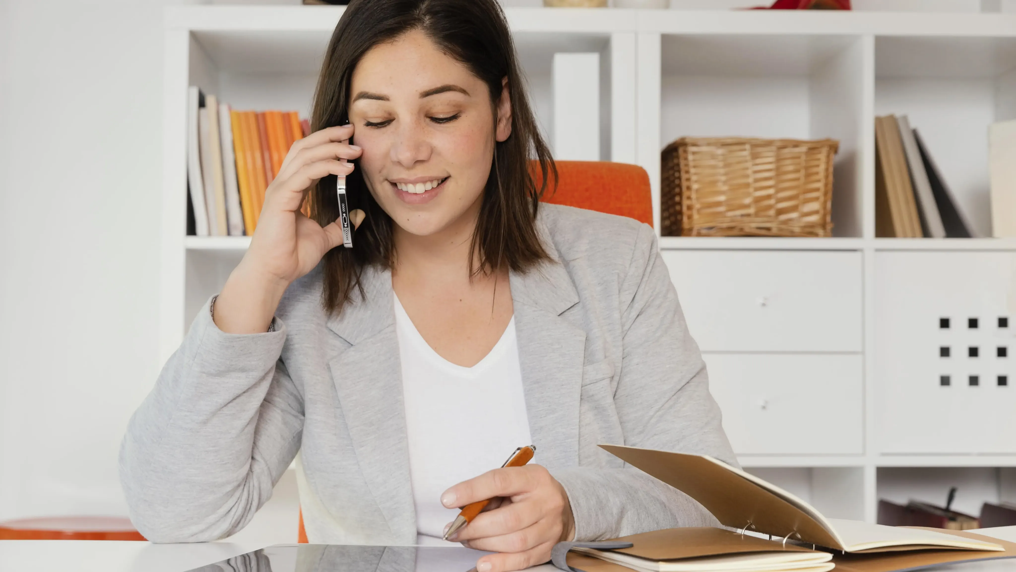 Woman talking while writing down notes